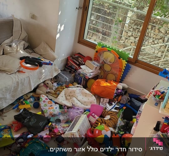 חדר מבולגן עם צעצועים, ספרים ומשחקים מפוזרים על הרצפה